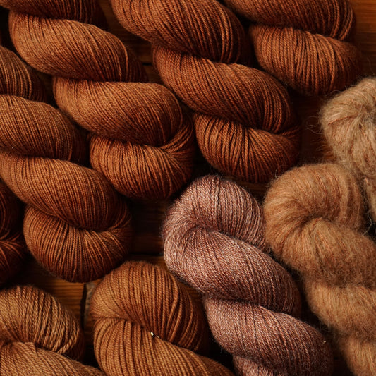 Close-up of brown yarn skeins on a wooden surface